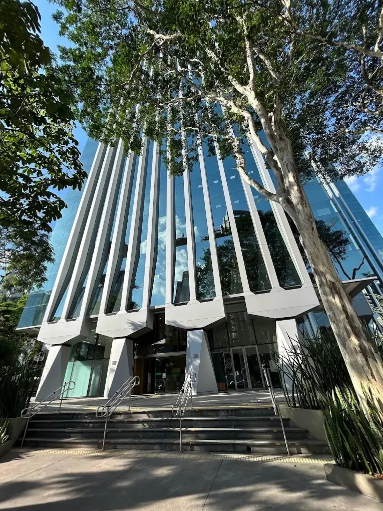 Consultório de psicologia em Pinheiros, São Paulo - fachada do edifício com vidro e árvores